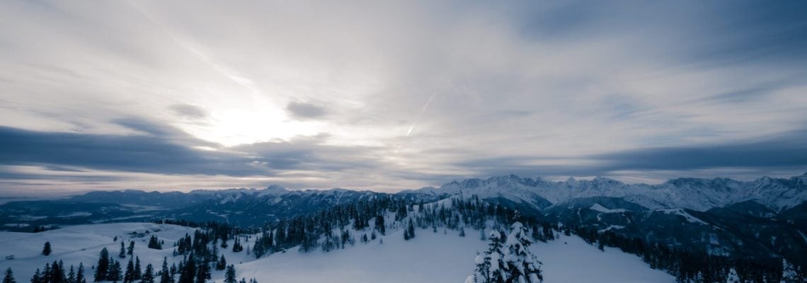 Winterlandschap met bergen aan de horizon en besneeuwde bomen