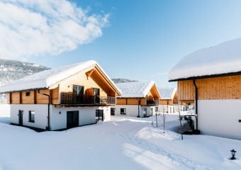 foto van meerder chalets op een zonnige winterdag