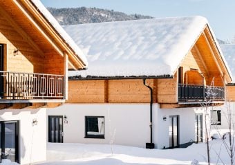 besneeuwd chalet met uitzicht op achterliggende bergen