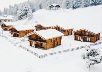 uitzicht over chalets in een dal die onder een ik pak sneeuw zitten