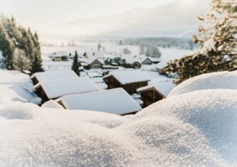 uitzicht over chalets in een dal die onder een ik pak sneeuw zitten