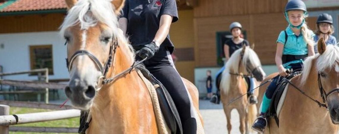 Kinderen die op vier paarden een ritje maken
