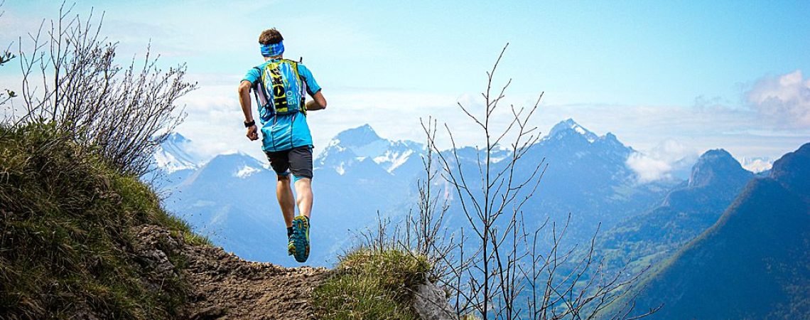 Een man die een trailrun doet in de bergen